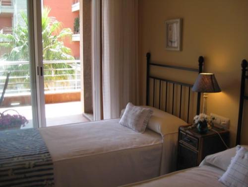 een slaapkamer met 2 bedden en een glazen schuifdeur bij Residencial Progreso Sanxenxo in Sanxenxo