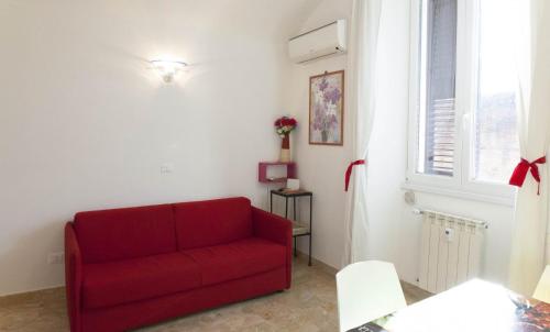 a red couch in a living room with a window at Between Termini & Colosseo in Rome