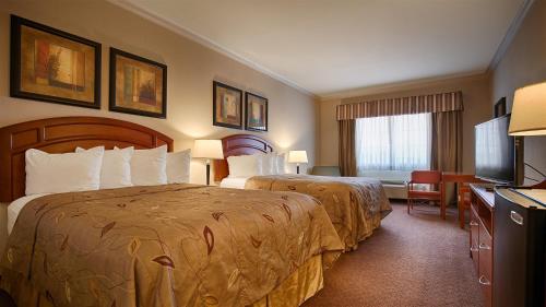 Een bed of bedden in een kamer bij Best Western Inn & Suites Cleveland