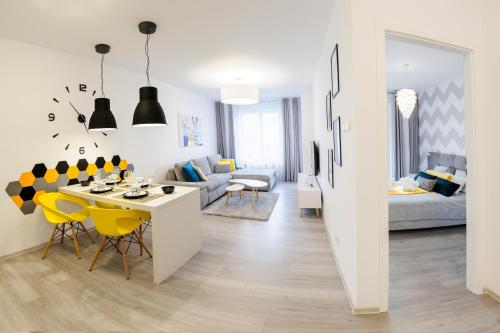 Biały salon ze stołem i żółtymi krzesłami w obiekcie Green Point Apartment Kołobrzeg w Kołobrzegu