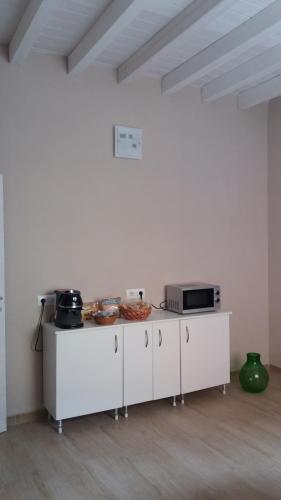 a white kitchen with a counter with a microwave at Da Valentina B&B in Elmas