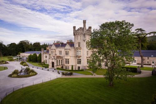 une image d'un grand château avec une pelouse dans l'établissement Lough Eske Castle, à Donegal