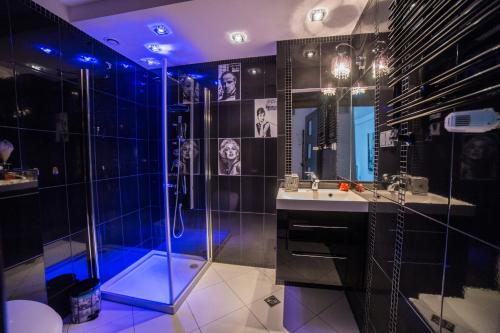 La salle de bains est pourvue d'une douche et d'un lavabo. dans l'établissement Top Apartamenty, à Kielce