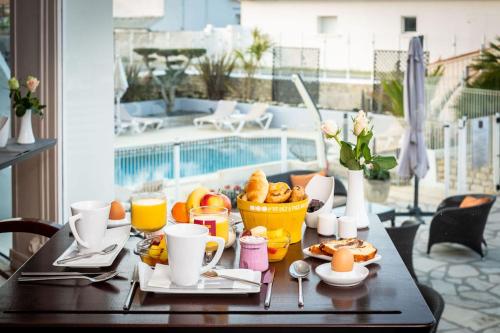 - une table avec des aliments pour le petit-déjeuner et des boissons sur un balcon dans l'établissement Face aux Flots, à La Cotinière