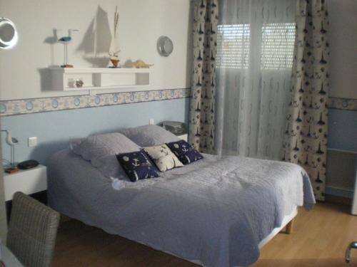 Largillay的住宿－La clé des champs，卧室配有一张带灰色床单和枕头的床。