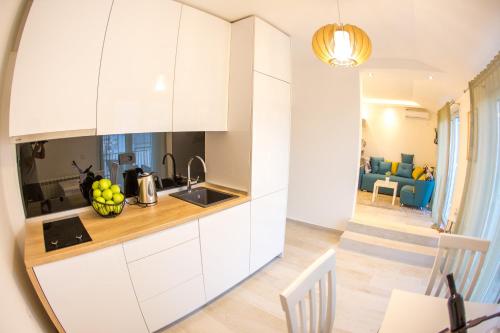 a kitchen with white cabinets and a dining room at Apartment Novak in Budva