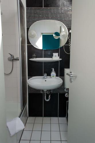 a bathroom with a sink and a mirror at Hotel Mainzer Hof in Dieburg