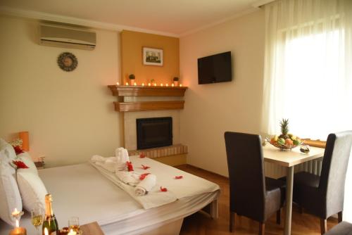 una sala de estar con una mesa y una chimenea en Apartmani Boss, en Vrnjačka Banja