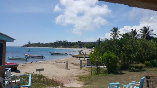 a beach with boats and people in the water at Waikiki Guest House in Treasure Beach