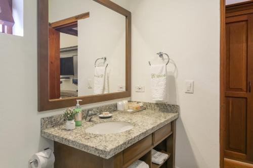 a bathroom with a sink and a mirror at La Casa Del Arbol Hotel Boutique Villa de Leyva in Villa de Leyva