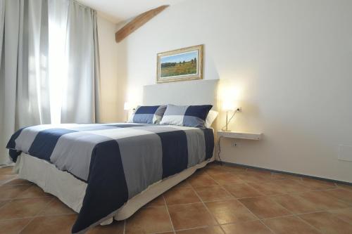 a bedroom with a bed with blue and white sheets at Locanda La Bottega del Parco in Pisa