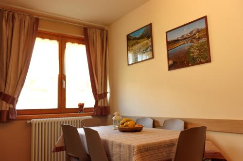 a dining room table with a bowl of fruit on it at Casa dello Sciatore in Bormio