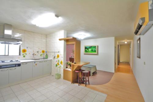 a kitchen with white cabinets and a table at 博愛泊旅讀心境 in Hualien City