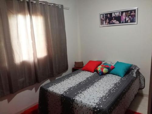 a bedroom with a bed with two pillows on it at Casa Nova Ótima Escolha in Bonito