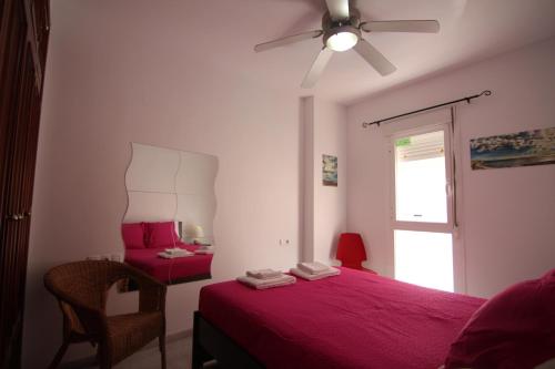 - une chambre avec un lit rouge et une fenêtre dans l'établissement Apartamento VELADOR del Sur by Cadiz4Rentals, à Cadix