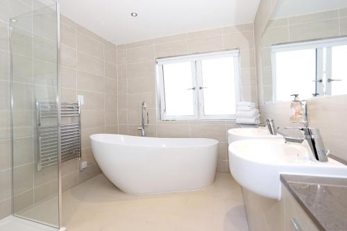 a bathroom with a large white tub and two sinks at Invercarse Hotel Dundee, BW Signature Collection in Dundee