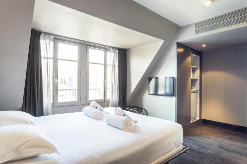 a bedroom with a large white bed with towels on it at CMG - Suite Premium Tour Eiffel - 71 in Paris