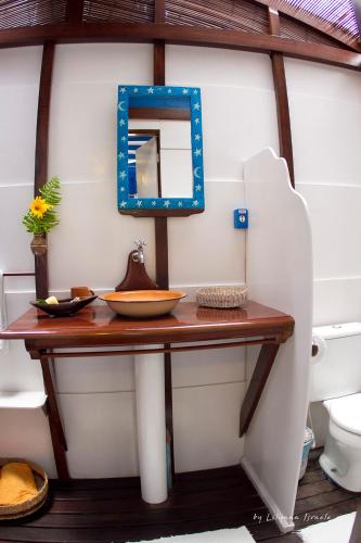 a bathroom with a table with a mirror and a toilet at Pousada Vila Sereia in Ilha de Boipeba