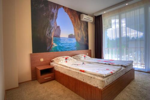 ein Schlafzimmer mit einem Bett und einem Gemälde an der Wand in der Unterkunft Stella Del Mare Guest House in Kiten