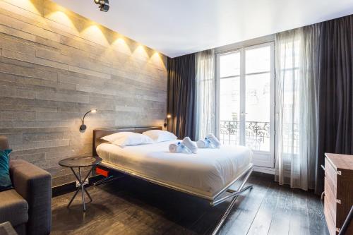 パリにあるCMG - Suite Premium Tour Eiffel - 21のベッドと窓が備わるホテルルーム