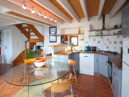 - une cuisine avec une table en verre et des chaises dans l'établissement Gouelet Ker, à Logonna-Daoulas