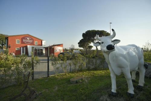 a statue of a cow standing in the grass at Locanda La Bottega del Parco in Pisa