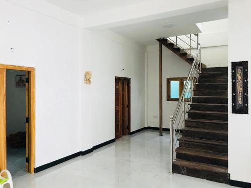 a staircase in a room with a white wall at Birunthavanam in Vavuniya