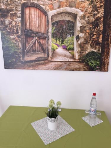 una pintura de una puerta abierta con una planta sobre una mesa en Pension Lindenhof en Limburg an der Lahn