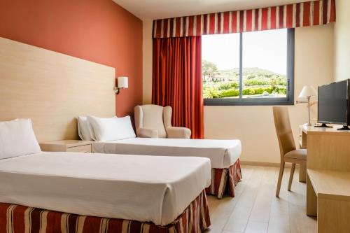 a hotel room with two beds and a window at Crisol La Selva in La Selva del Camp