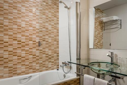 a bathroom with a glass sink and a tub at Crisol La Selva in La Selva del Camp