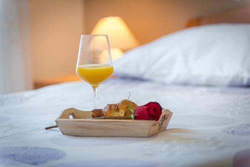 un piatto di cibo e un bicchiere di vino su un letto di Villa Adria a Cavtat