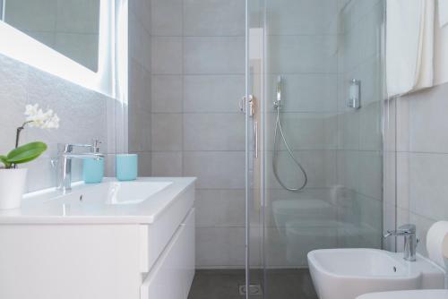 a white bathroom with a shower and a sink at Lux in Naples