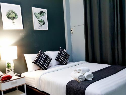 a hotel room with two beds with towels on them at Baan Pinklao in Bangkok