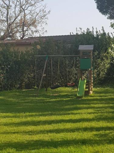 a playground with a swing set in a yard at Locanda La Bottega del Parco in Pisa