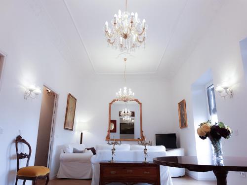 a white living room with a chandelier and a table at Casa Palacio Morla y Melgarejo in Jerez de la Frontera