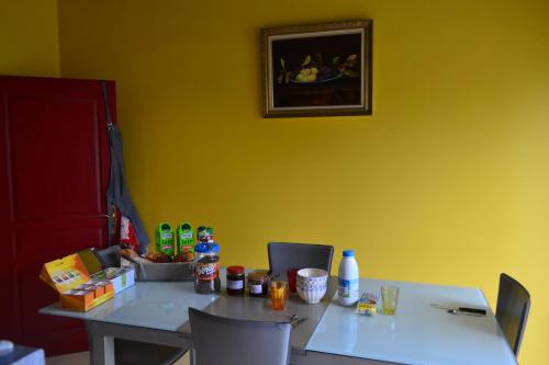 une table dans une pièce avec un mur jaune dans l'établissement Les Chambres de Carreau, à Meilhan-sur-Garonne