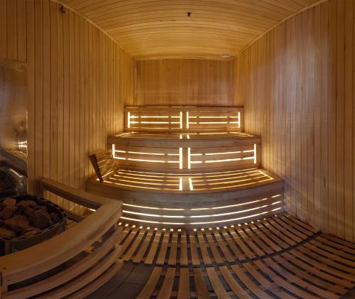 a sauna with wooden benches and lights in it at Fantasia Hotel in Polyana