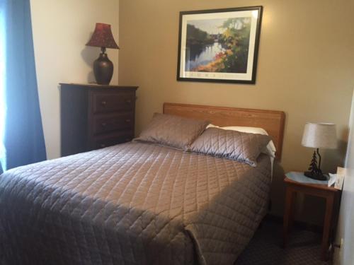 1 dormitorio con 1 cama y una foto en la pared en Milford Motel On the River en Milford