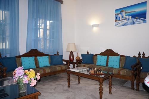 a living room with two couches and a table at Adonis Hotel Naxos in Apollon