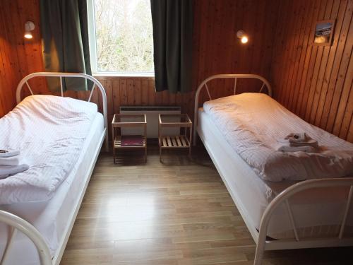 two beds in a small room with a window at apartment Neðra-Vatnshorn in Hvammstangi