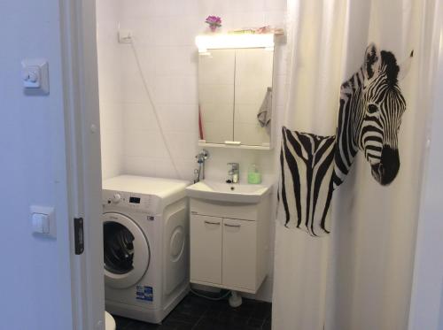 a bathroom with a shower curtain with a zebra on it at Heleenkatu 3 a 1 oma sauna autokatos omassa pihassa in Seinäjoki