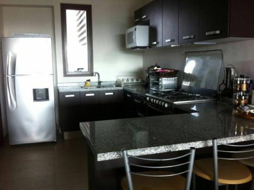 a kitchen with a refrigerator and a counter top at Departamento en La Isla Acapulco Torre H in Acapulco