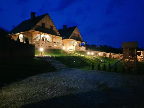 a large wooden house at night with lights at Domki pod Kuźnią in Falsztyn