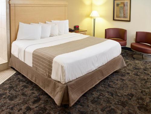 a hotel room with a large bed and a chair at LivINN Hotel Minneapolis South / Burnsville in Burnsville