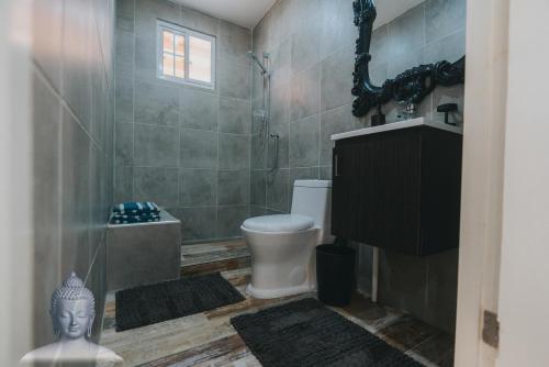 a bathroom with a toilet and a shower and a sink at Buddha Studios Aruba in Palm-Eagle Beach