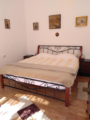 a bed in a bedroom with a wooden floor at Mama Brasov in Braşov