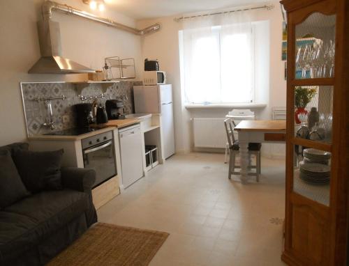 a kitchen with a couch and a table in a room at Una finestra sul lago..Appartamento Verbania in Verbania