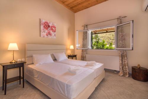 ein Schlafzimmer mit einem großen Bett und einem Fenster in der Unterkunft Villa Nina in Kerion