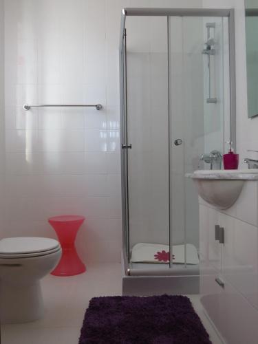 a bathroom with a shower and a toilet and a sink at Alojamento Cesarini in Montijo