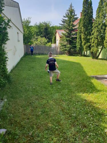 a young boy is walking in the grass at Zseki apartman in Hajdúszoboszló